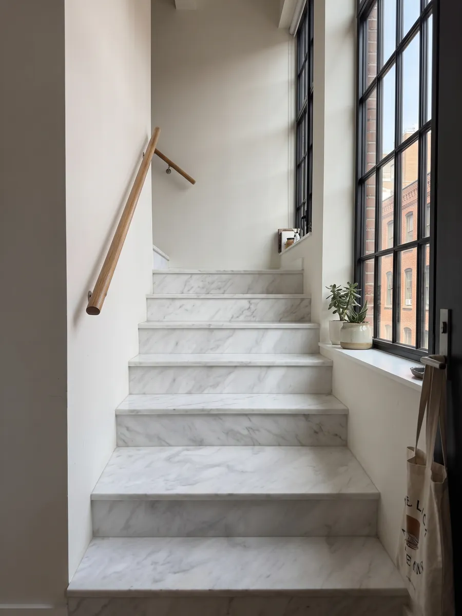 Escalera interior con peldaños de Mármol Blanco Bego con pasamanos: blanco con un veteado gris claro suave