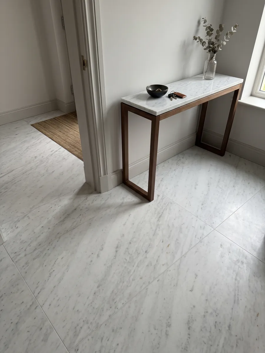 Piso de recibidor en placas grandes de Mármol Blanco Brasile con luz natural: blanco frío casi liso con líneas grises tenues en diagonal