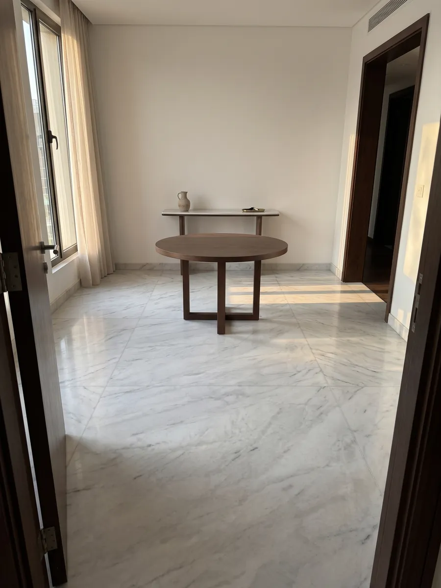Piso de recibidor en placas grandes de mármol blanco Dolomita con luz natural: blanco grisáceo con vetas grises finas y alguna línea más oscura