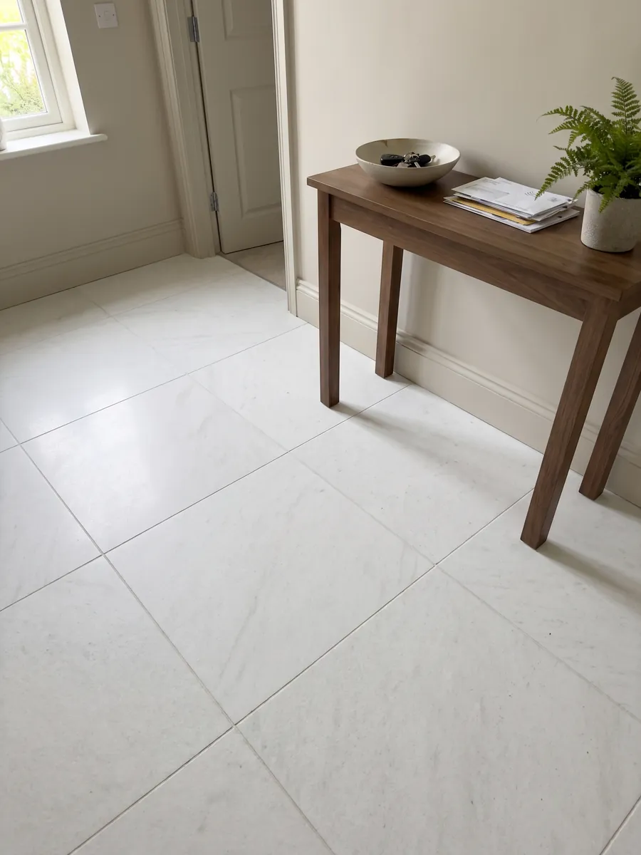 Piso de recibidor en placas grandes de Mármol Blanco Ghiaccio con luz natural: blanco puro casi sin dibujo visible