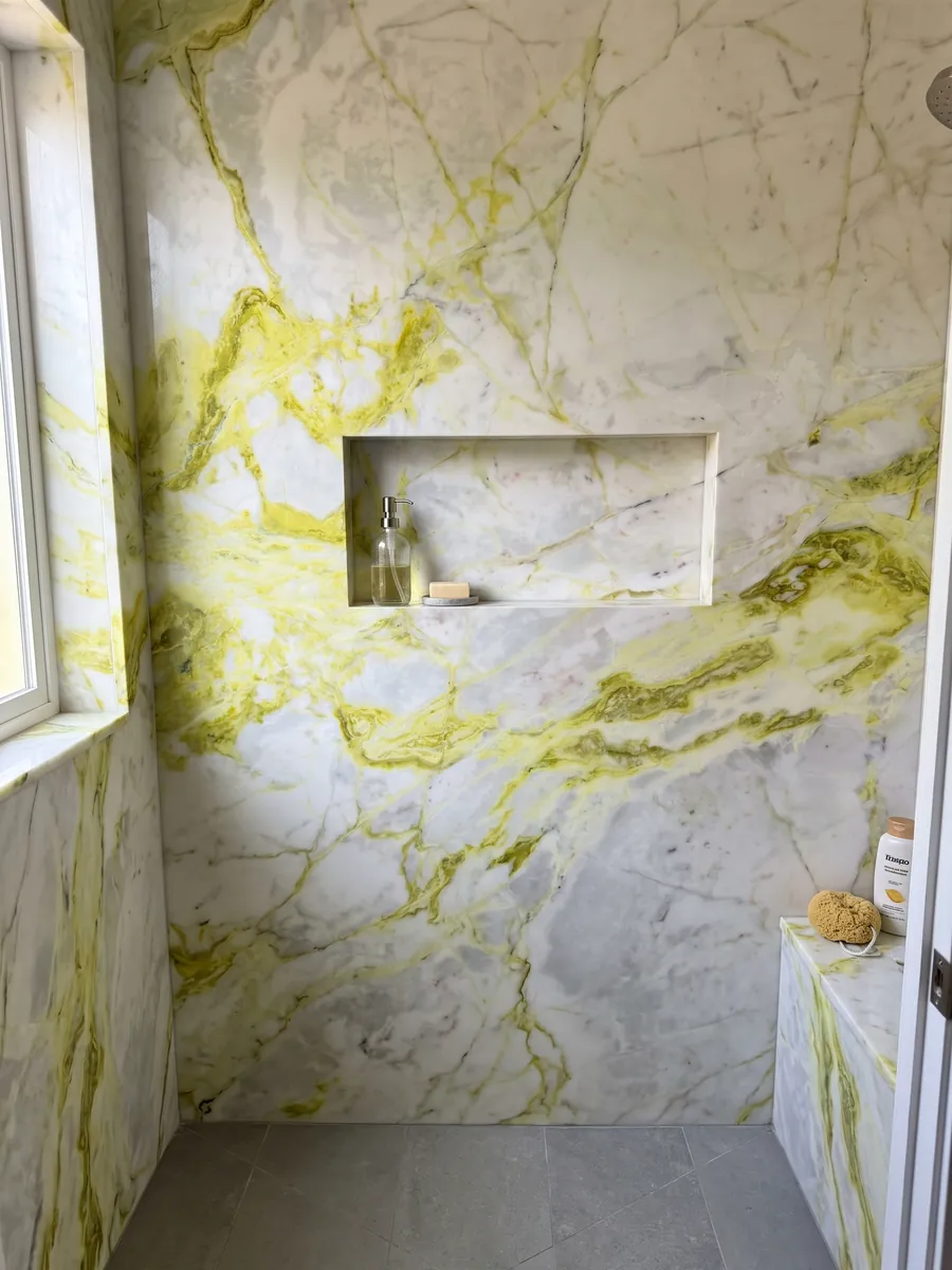 Ducha revestida con placas enteras de mármol blanco Luminous con nicho empotrado: blanco azulado con vetas amarillo limón muy intensas