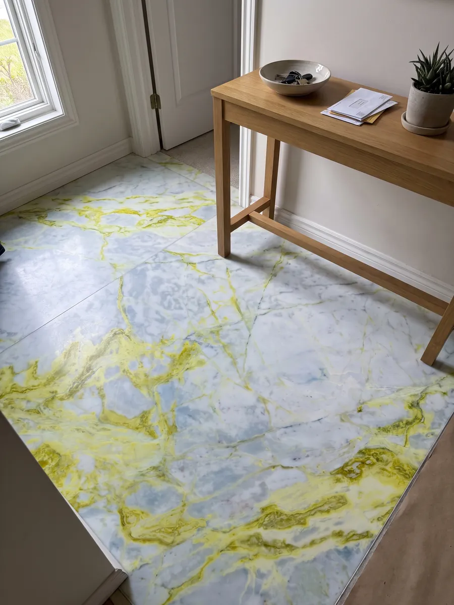 Piso de recibidor en placas grandes de mármol blanco Luminous con luz natural: blanco azulado con vetas amarillo limón muy intensas