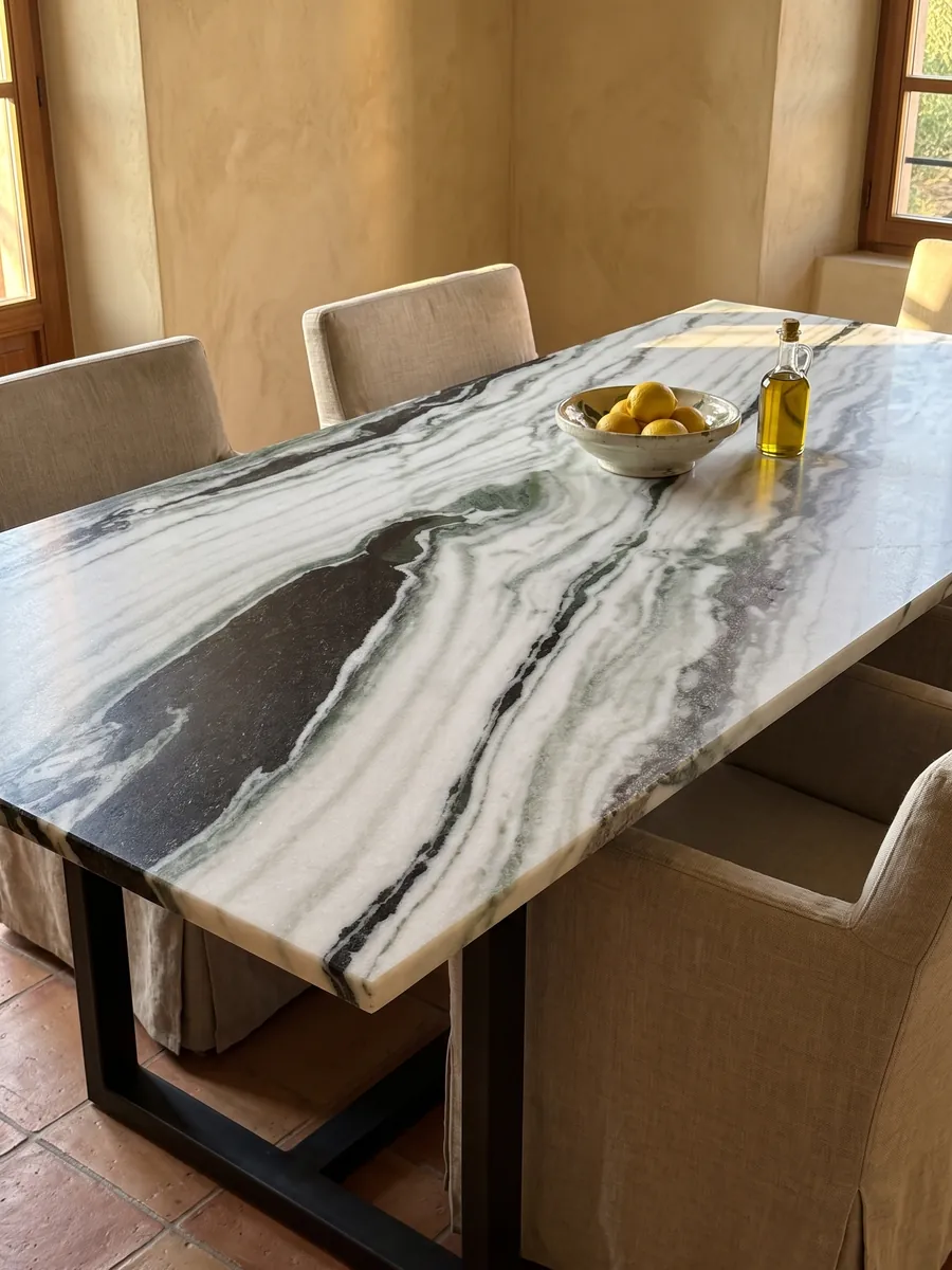 Mesa de comedor con cubierta de mármol blanco Panda White sobre base de acero: blanco con bandas negras diagonales gruesas y toques verdes