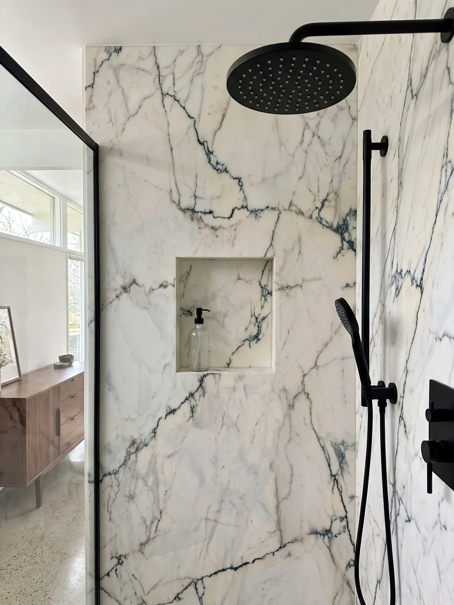 Ducha revestida con placas enteras de mármol blanco Paonazzo con nicho empotrado: blanco cálido con vetas finas verde azulado oscuro que parecen grietas