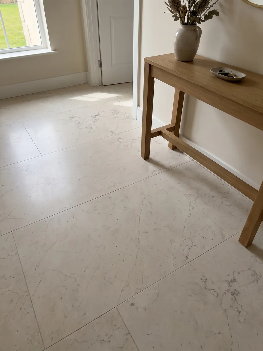 Piso de recibidor en placas grandes de Mármol Blanco Perlino con luz natural: marfil liso con vetas grises muy finas tipo hilo dispersas