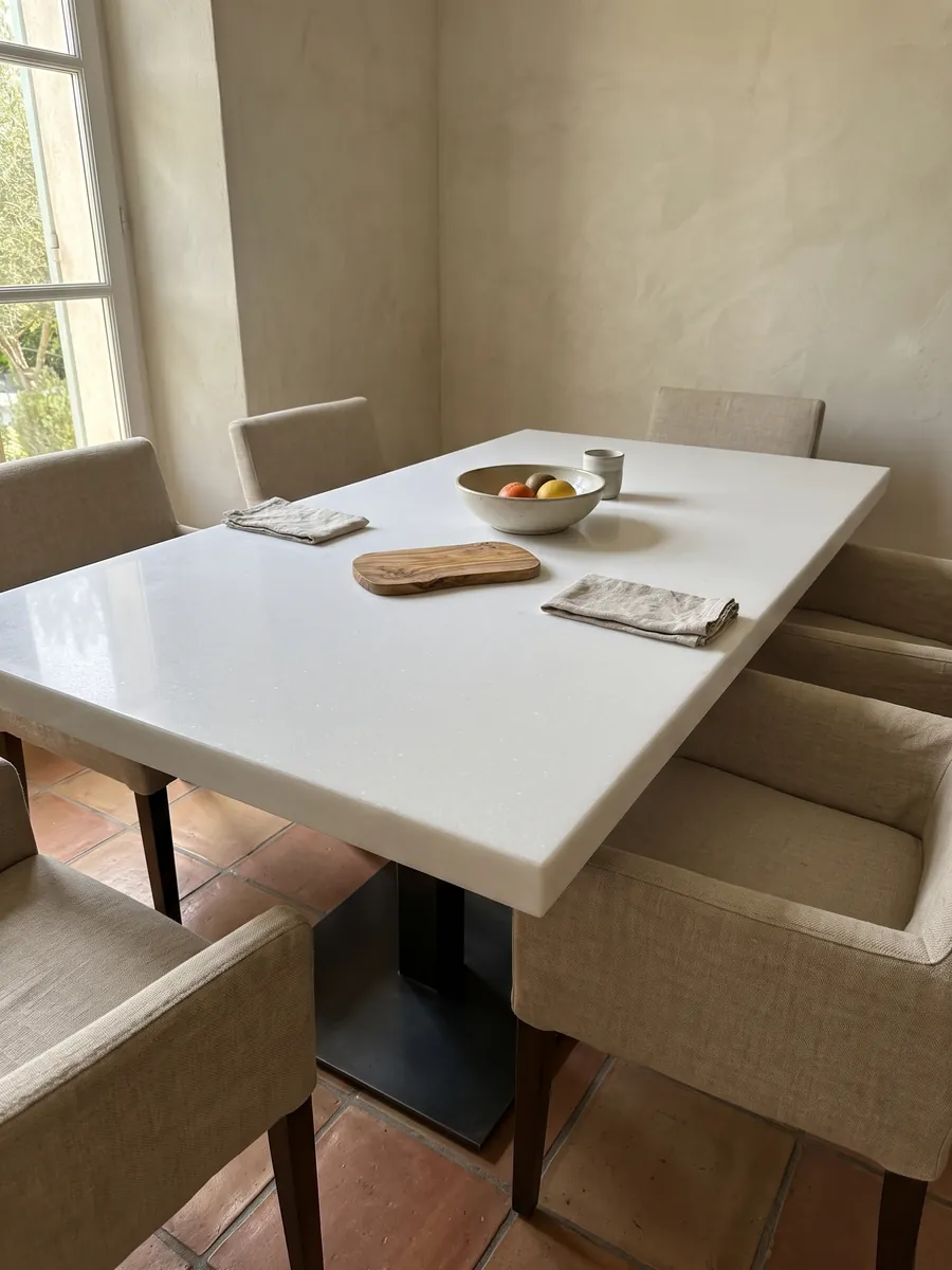 Mesa de comedor con cubierta de mármol blanco Pure White sobre base de acero: blanco puro uniforme, sin vetas ni manchas visibles