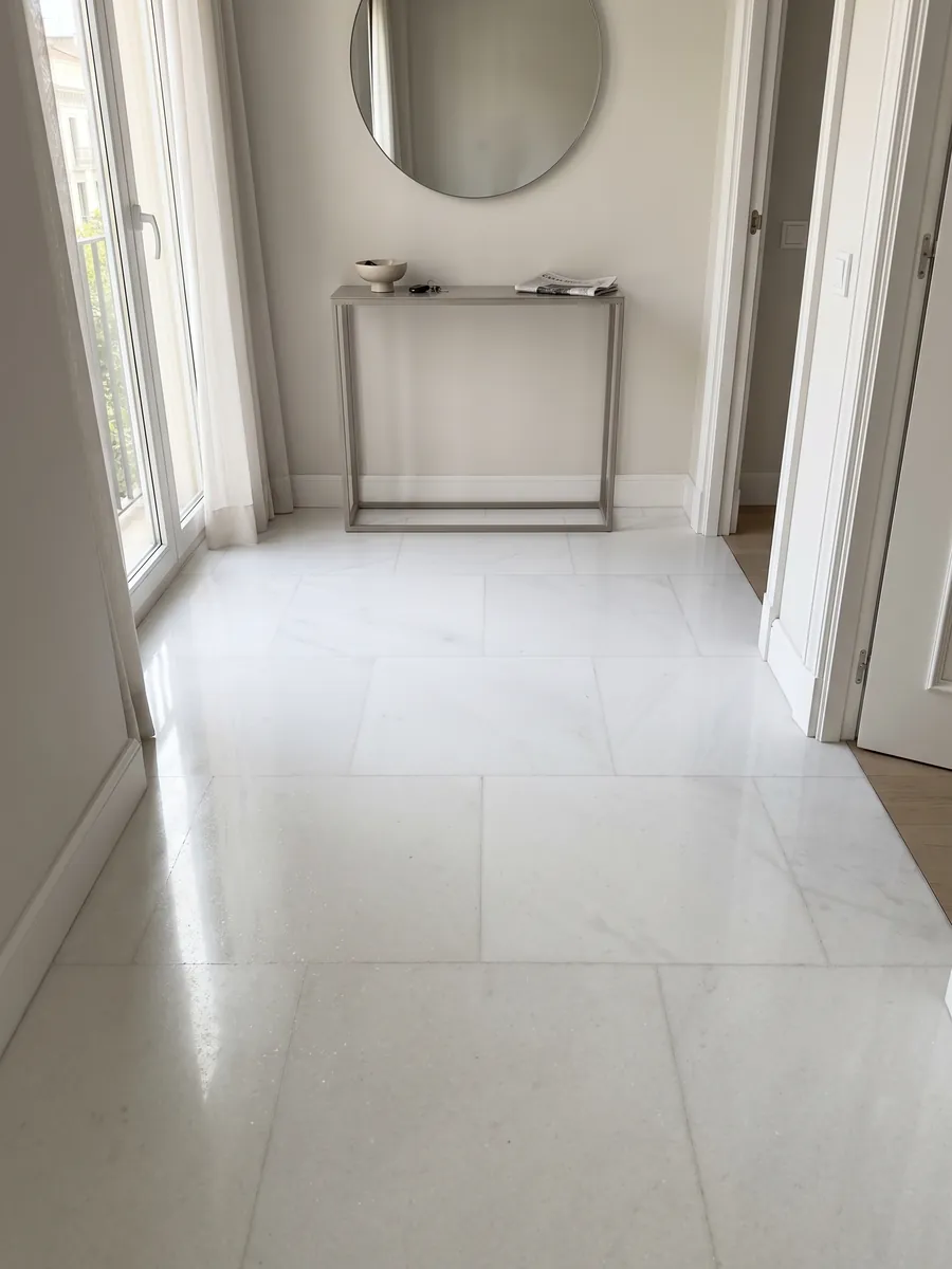 Piso de recibidor en placas grandes de mármol blanco Pure White con luz natural: blanco puro uniforme, sin vetas ni manchas visibles