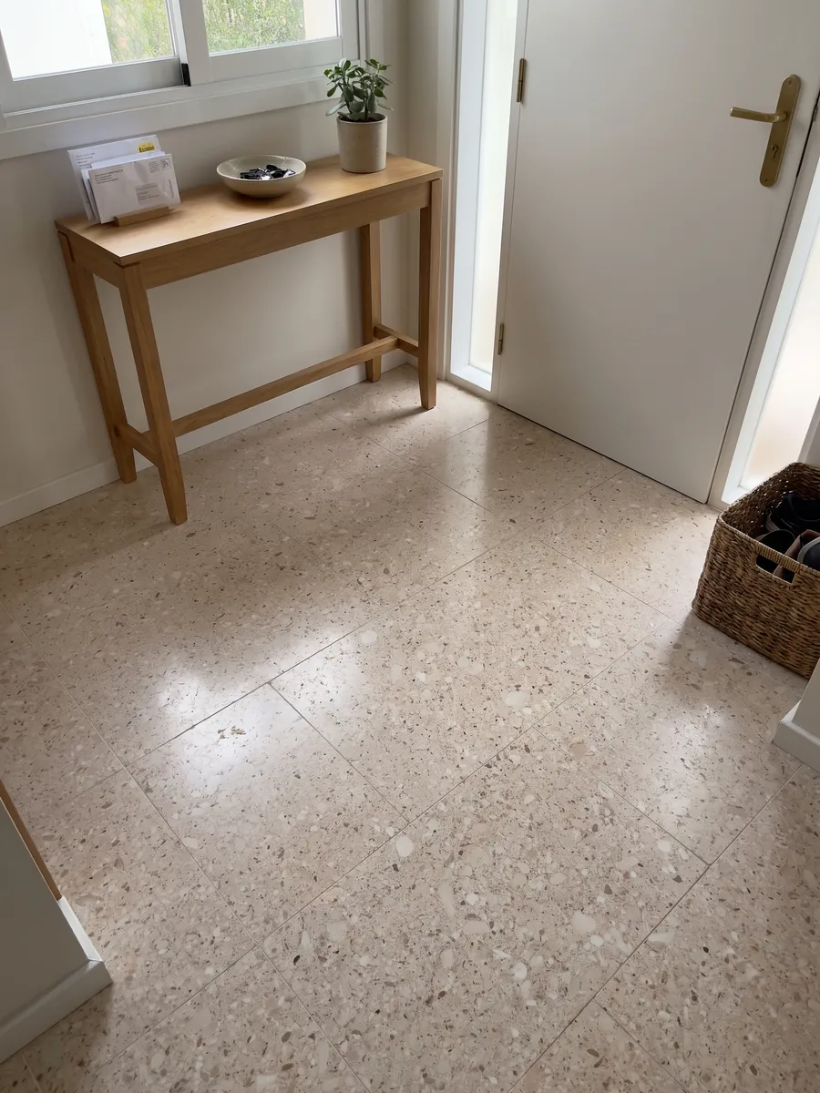 Piso de recibidor en placas grandes de Mármol Blanco Romano con luz natural: beige rosado salpicado de pequeños clastos redondeados blancos y marrones