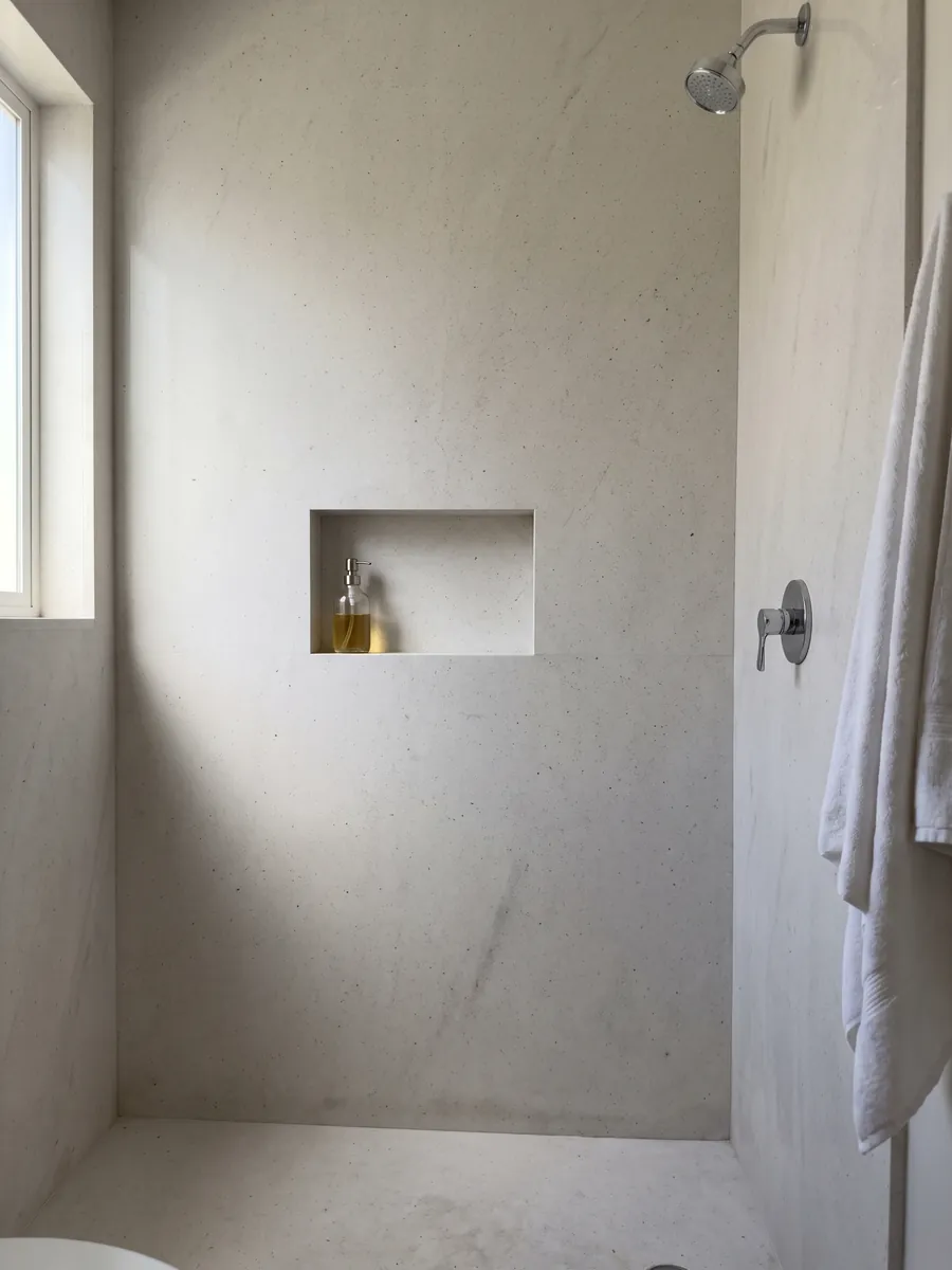Ducha revestida con placas enteras de Mármol Blanco Siberia con nicho empotrado: blanco grisáceo liso con pequeños puntos oscuros dispersos