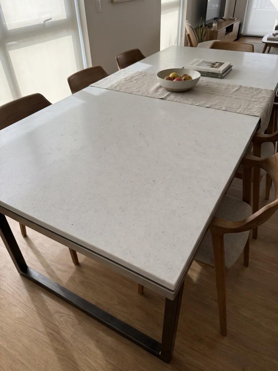 Mesa de comedor con cubierta de Mármol Blanco Siberia sobre base de acero: blanco grisáceo liso con pequeños puntos oscuros dispersos