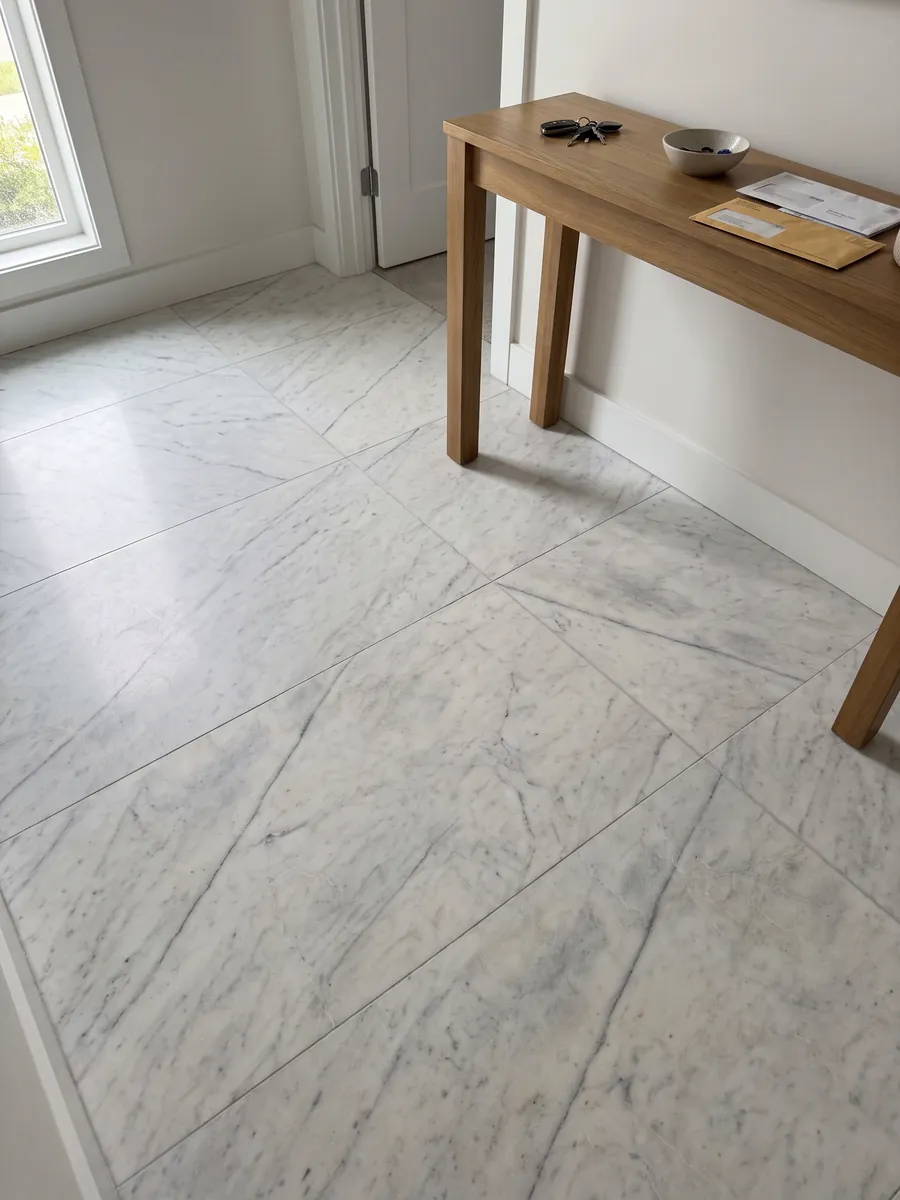 Piso de recibidor en placas grandes de mármol blanco Silver Glace con luz natural: blanco limpio con pocas vetas grises finas en diagonal