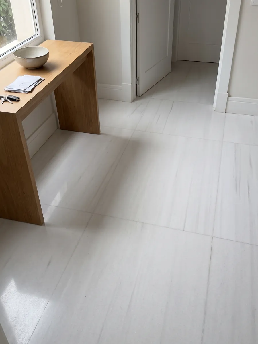 Piso de recibidor en placas grandes de Mármol Blanco Sivec con luz natural: blanco muy puro y homogéneo, prácticamente sin dibujo