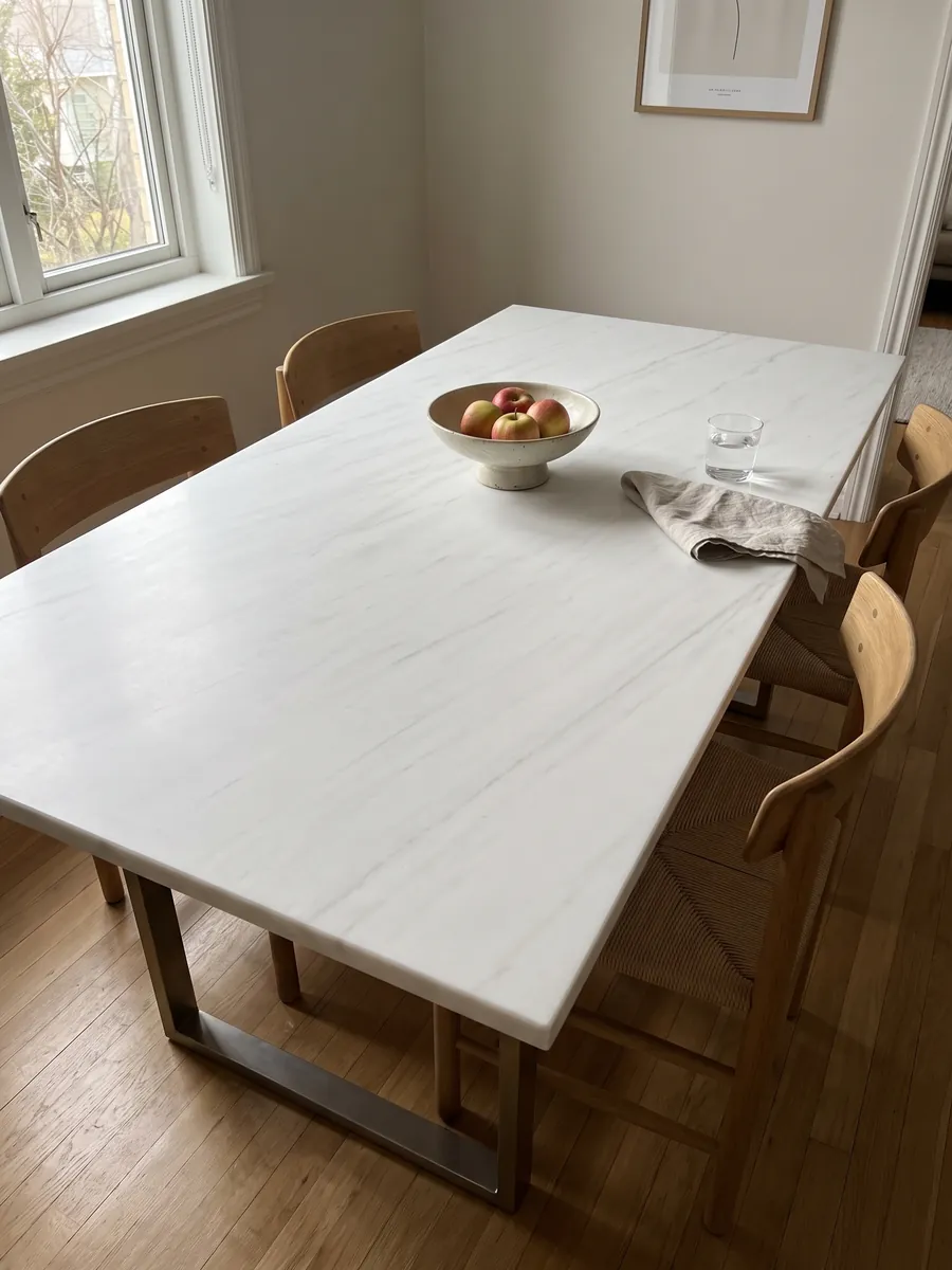 Mesa de comedor con cubierta de mármol blanco Snow White sobre base de acero: blanco muy limpio con trazos grises apenas perceptibles en diagonal