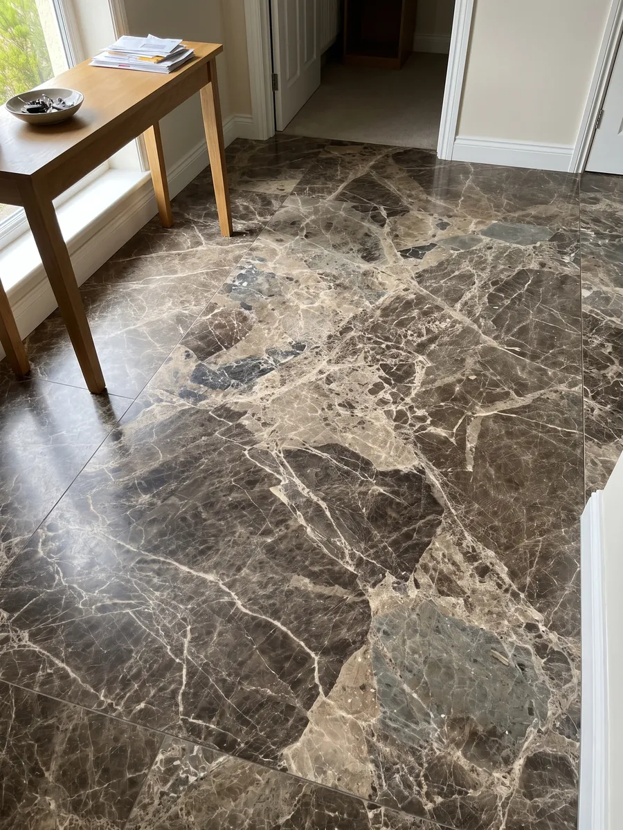 Piso de recibidor en placas grandes de mármol café Breccia Paradiso con luz natural: fragmentos grandes marrón grisáceo unidos por una red de vetas beige claras
