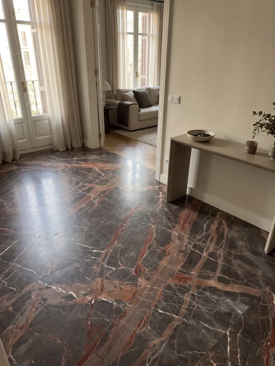 Piso de recibidor en placas grandes de mármol café Ombra di Caravaggio con luz natural: gris pardo oscuro cruzado por vetas terracota anchas y vetas blancas finas