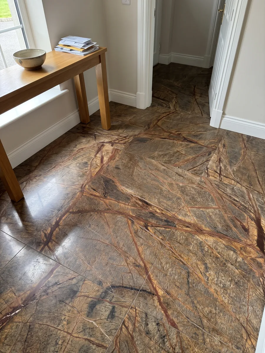 Piso de recibidor en placas grandes de mármol café Picasso Brown con luz natural: marrón oliva cruzado por una red de vetas rojo óxido