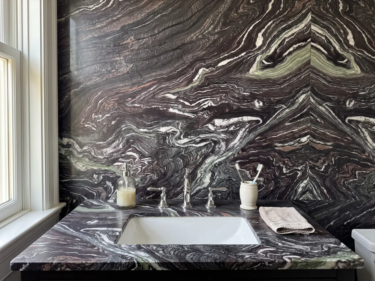 Cubierta de lavabo y pared de baño en Mármol Cipollino Ondulato con lavamanos blanco y grifería cromada: fondo morado oscuro con vetas blancas muy onduladas y plegadas