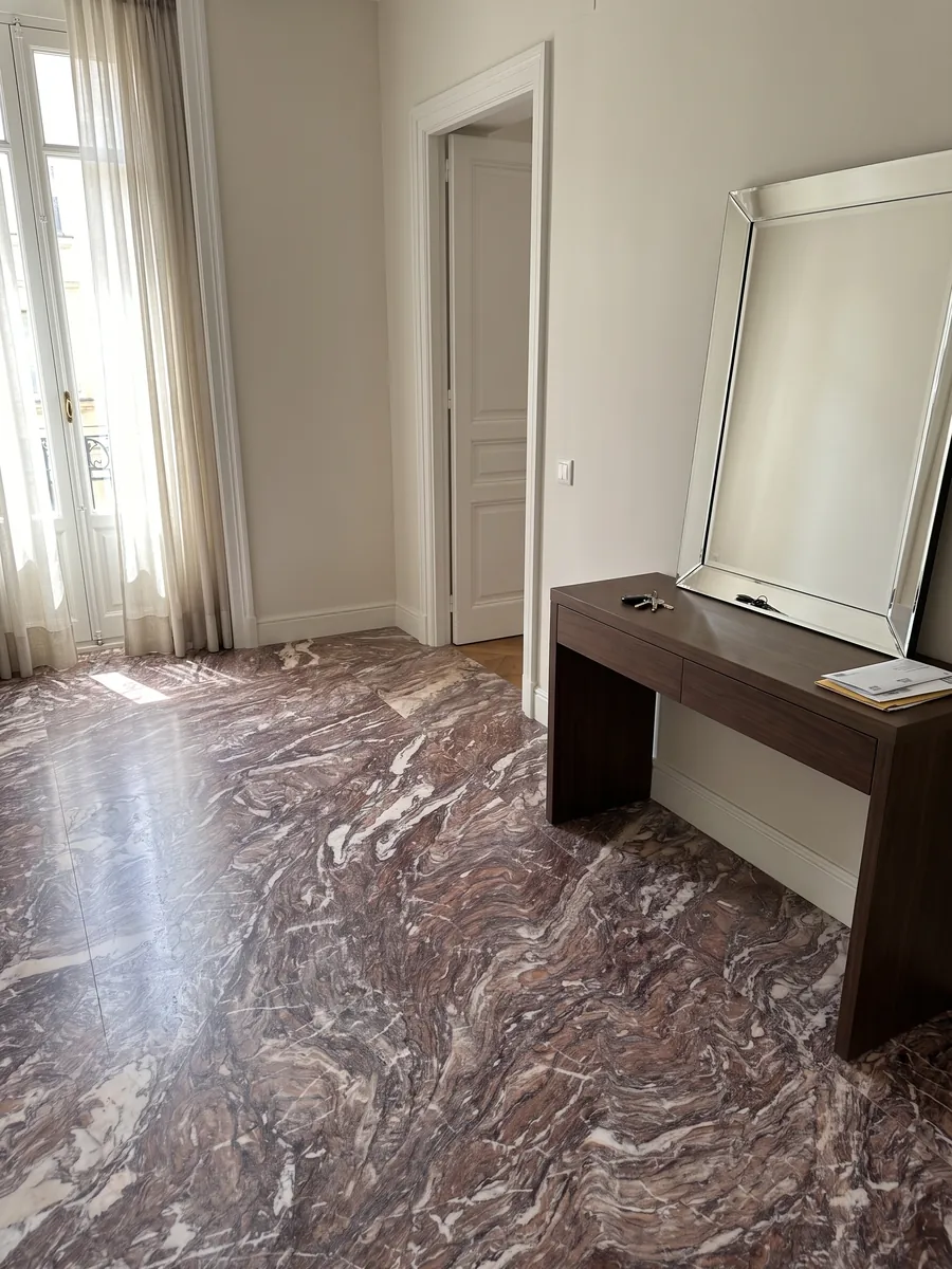 Piso de recibidor en placas grandes de Mármol Cipollino Viola con luz natural: violeta rojizo con pliegues finos densos y algunas vetas blancas
