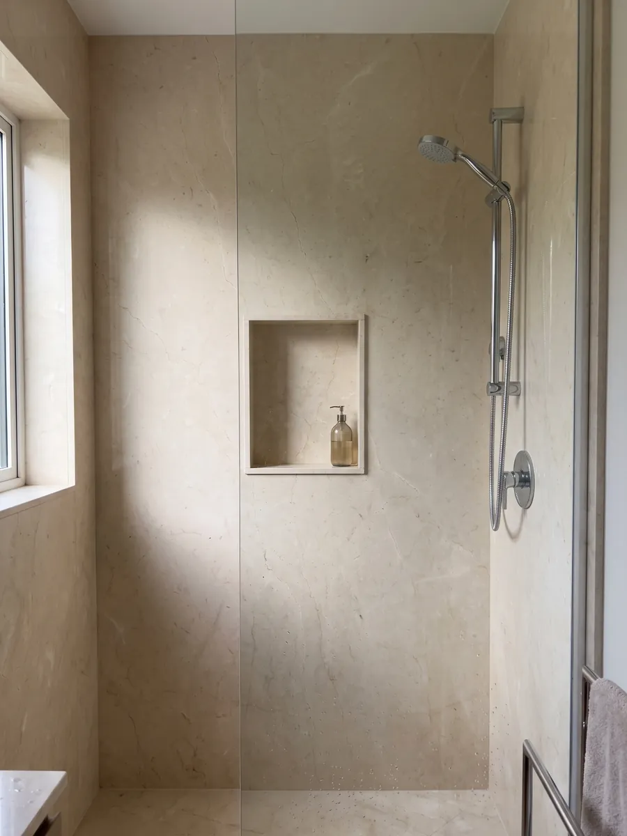 Ducha revestida con placas enteras de Mármol Crema Marfil con nicho empotrado: crema uniforme casi sin dibujo