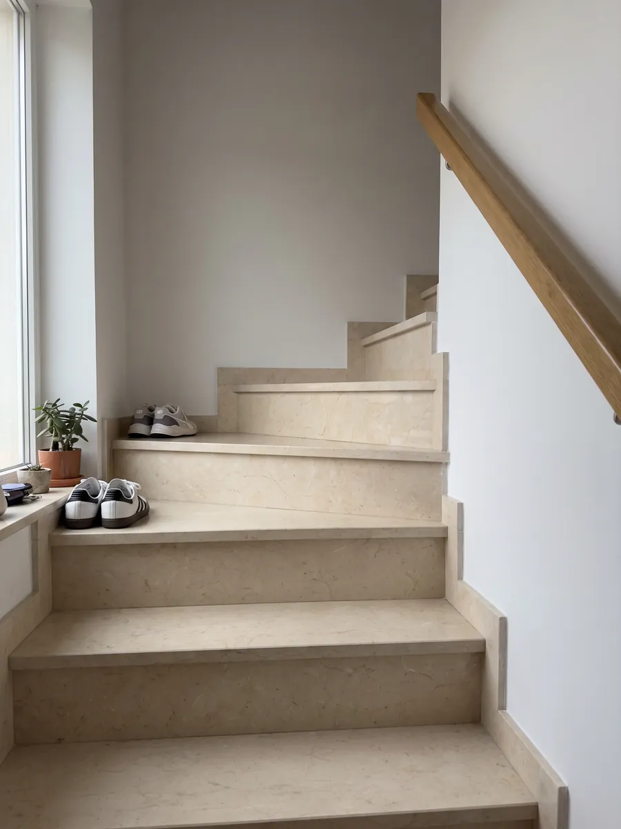 Escalera interior con peldaños de Mármol Crema Marfil con pasamanos: crema uniforme casi sin dibujo