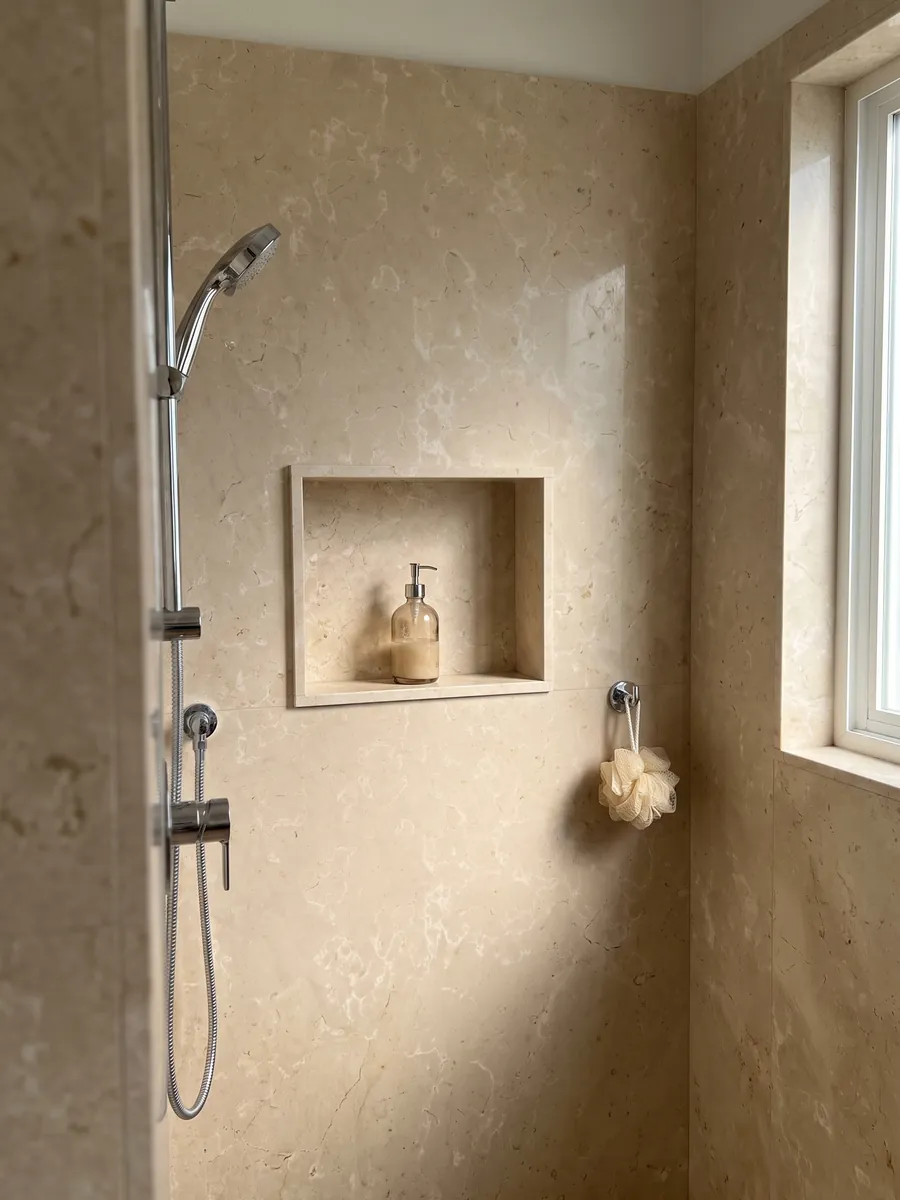 Ducha revestida con placas enteras de Mármol Crema Nuova con nicho empotrado: crema cálido con manchas claras difusas