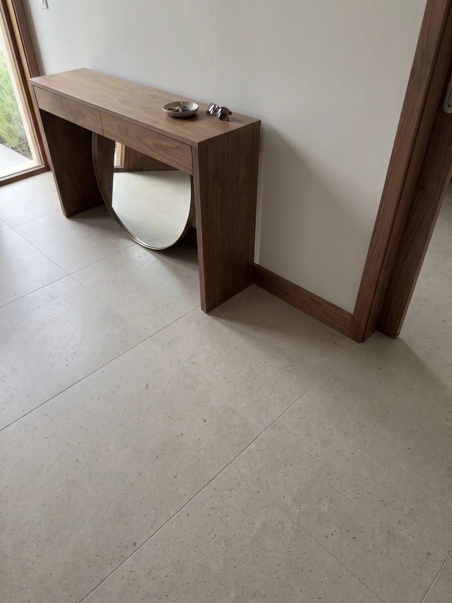 Piso de recibidor en placas grandes de Mármol Gascogne Beige con luz natural: beige grisáceo casi liso, con puntitos oscuros apenas visibles
