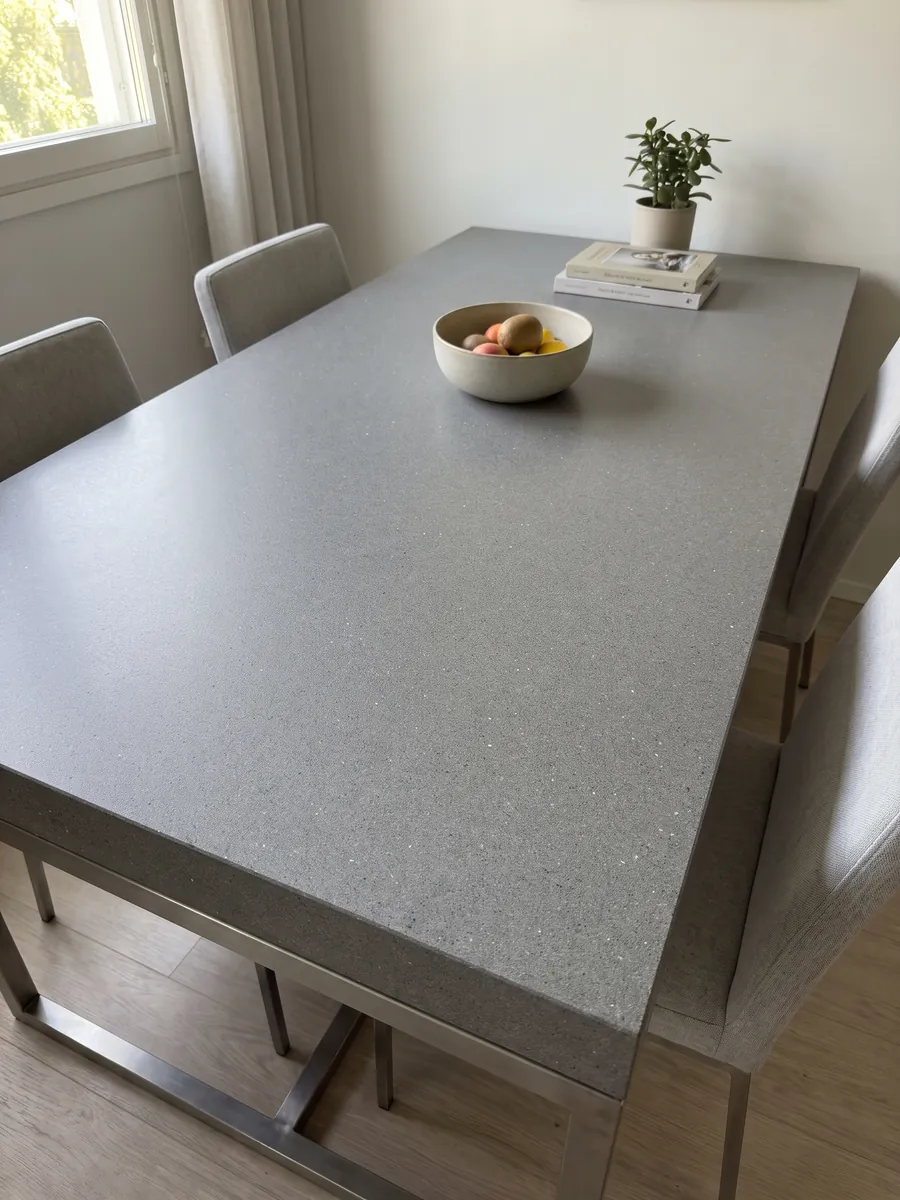 Mesa de comedor con cubierta de Mármol Gris Aitos sobre base de acero: gris medio de grano fino y salpicado parejo, sin vetas