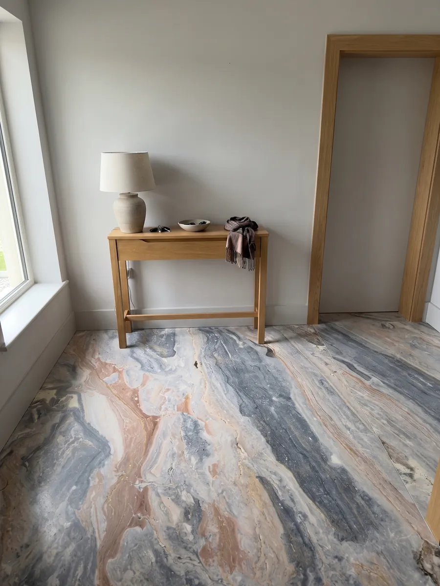 Piso de recibidor en placas grandes de mármol gris Arabescato Orobico Grigiorosa con luz natural: ondas mezcladas de gris azulado y rosa salmón en diagonal sobre toda la placa