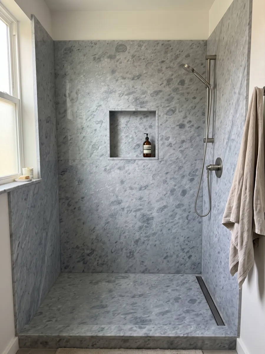 Ducha revestida con placas enteras de mármol gris Bardiglio Imperial con nicho empotrado: gris azulado uniforme con manchas redondeadas apenas más oscuras