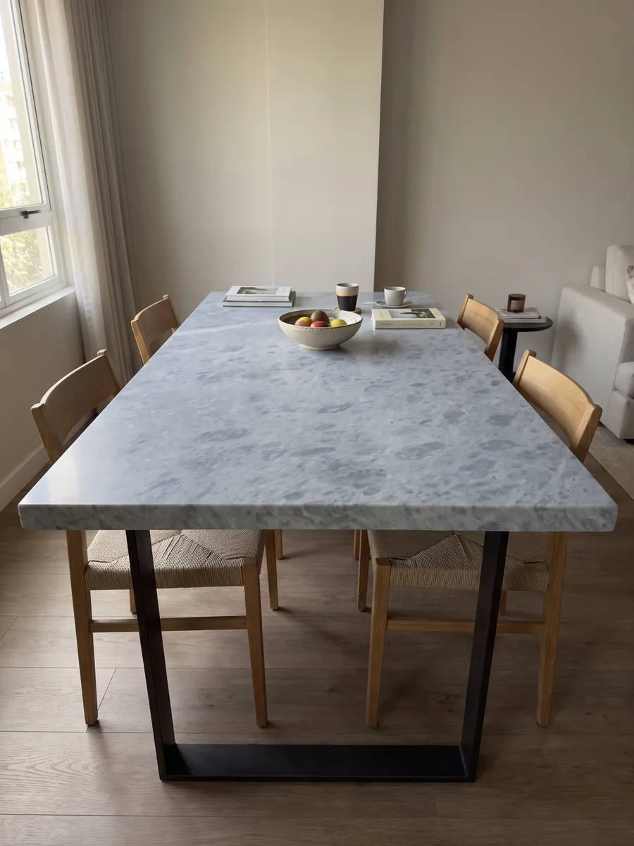 Mesa de comedor con cubierta de mármol gris Bardiglio Imperial sobre base de acero: gris azulado uniforme con manchas redondeadas apenas más oscuras