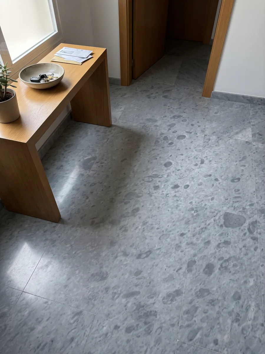 Piso de recibidor en placas grandes de mármol gris Bardiglio Imperial con luz natural: gris azulado uniforme con manchas redondeadas apenas más oscuras