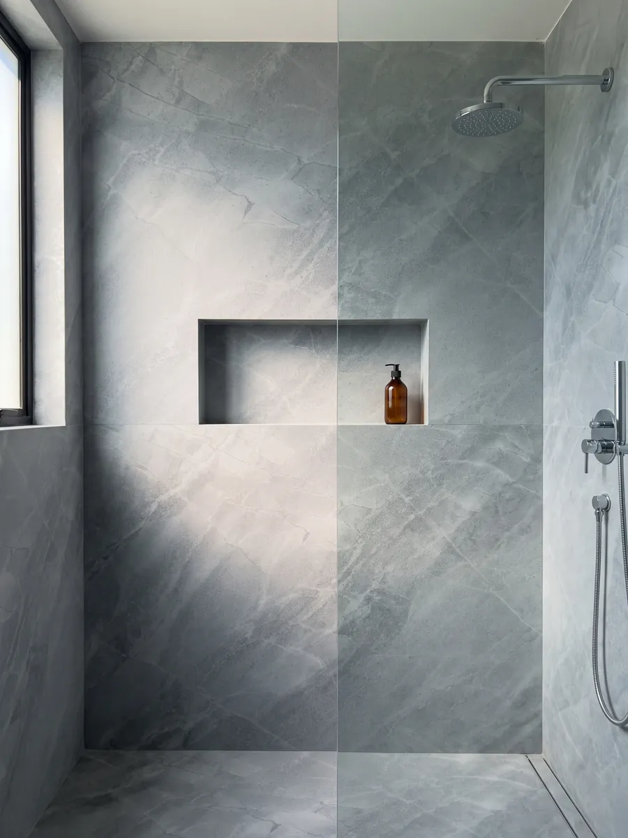 Ducha revestida con placas enteras de mármol gris Bleu de Savoie con nicho empotrado: gris azulado con vetas claras finas en red y nubes más claras