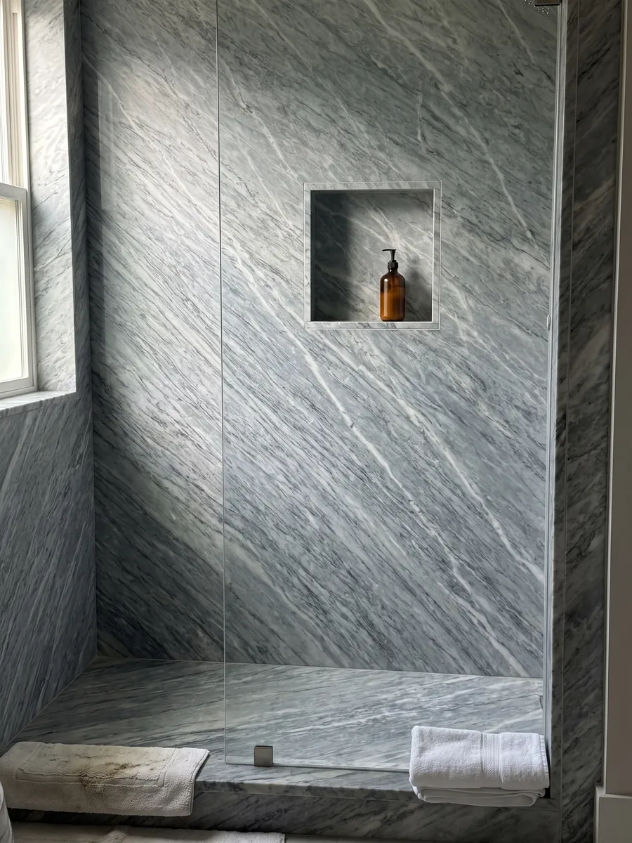 Ducha revestida con placas enteras de mármol gris Calacatta Bluette con nicho empotrado: gris azulado con trazos blancos y grises finos en diagonal muy densos