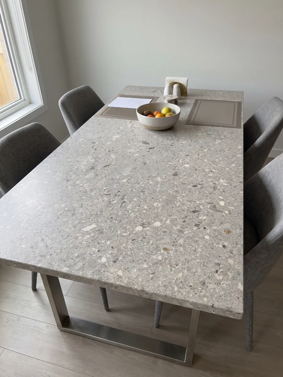 Mesa de comedor con cubierta de mármol gris Ceppo di Gré sobre base de acero: gris claro con pequeños fragmentos beige y grises repartidos