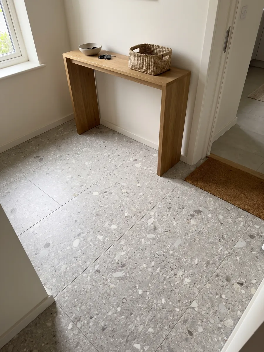 Piso de recibidor en placas grandes de mármol gris Ceppo di Gré con luz natural: gris claro con pequeños fragmentos beige y grises repartidos