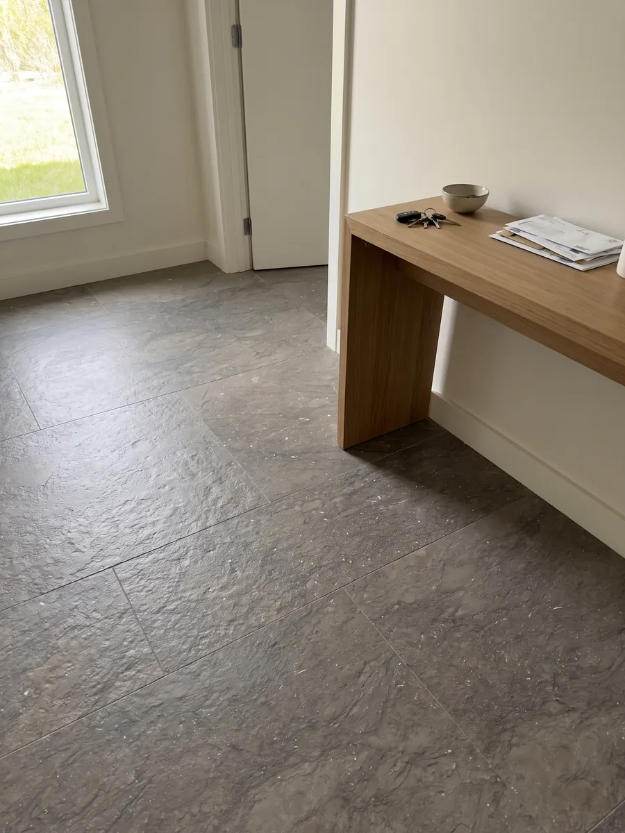Piso de recibidor en placas grandes de mármol gris Ebano con luz natural: gris pardo uniforme con pequeños puntos claros brillantes