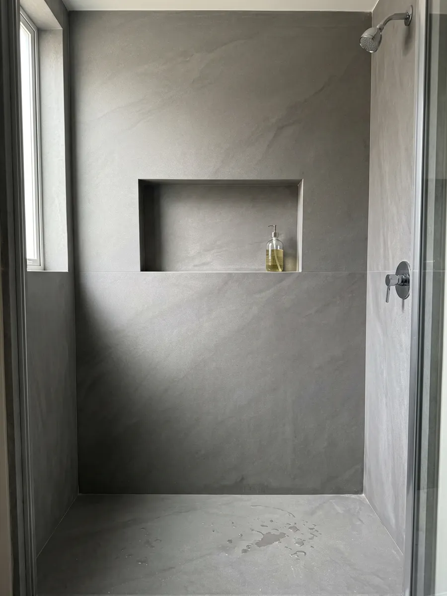 Ducha revestida con placas enteras de mármol gris Pietra Serena con nicho empotrado: gris medio liso y uniforme, sin vetas