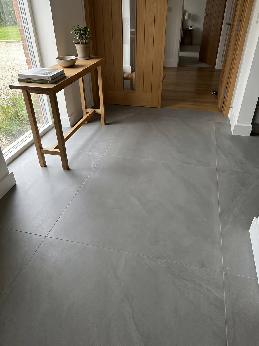 Piso de recibidor en placas grandes de mármol gris Pietra Serena con luz natural: gris medio liso y uniforme, sin vetas