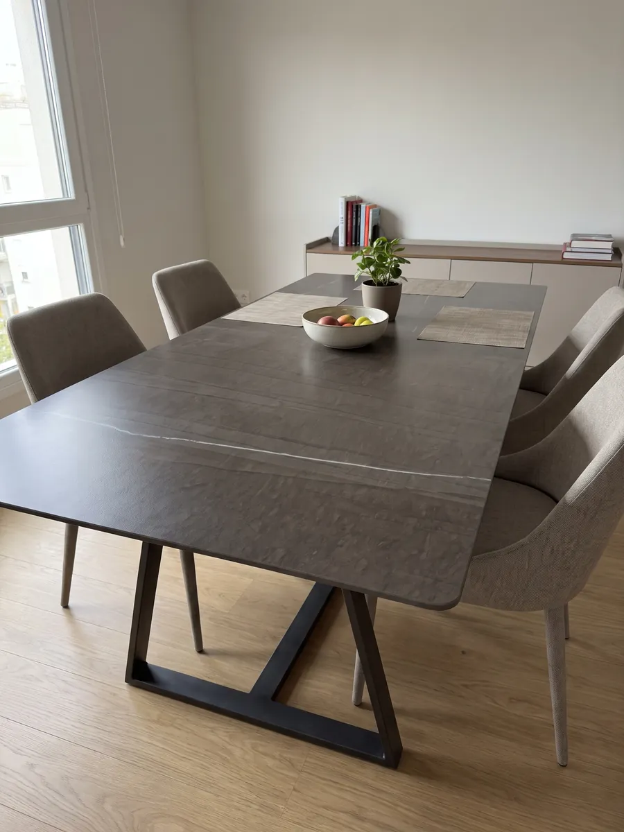 Mesa de comedor con cubierta de Mármol Gris Tao sobre base de acero: café oscuro con líneas verticales tenues y una única veta blanca fina