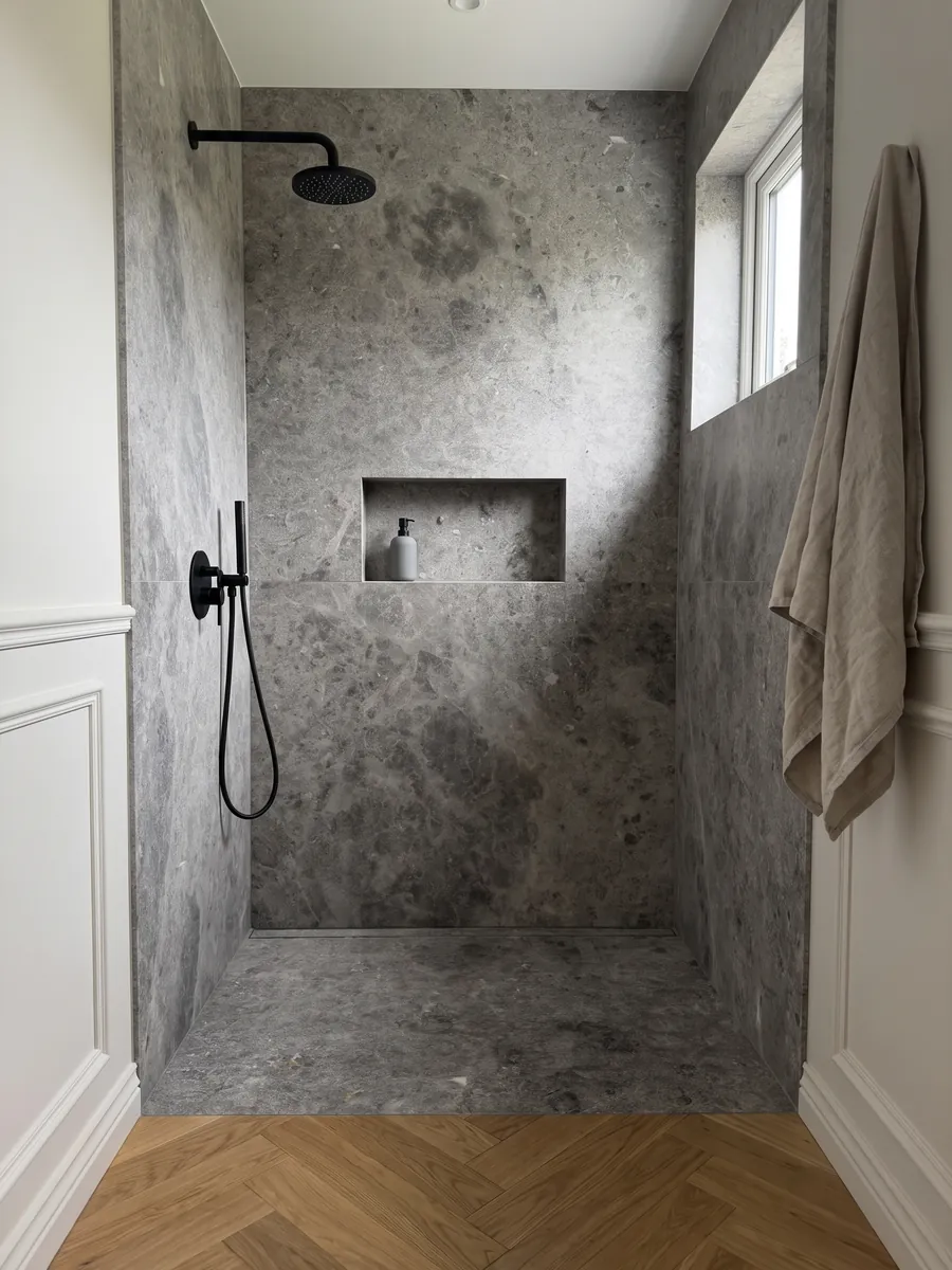 Ducha revestida con placas enteras de mármol gris Tundra con nicho empotrado: gris medio con nubes más oscuras y salpicado fino de puntos claros