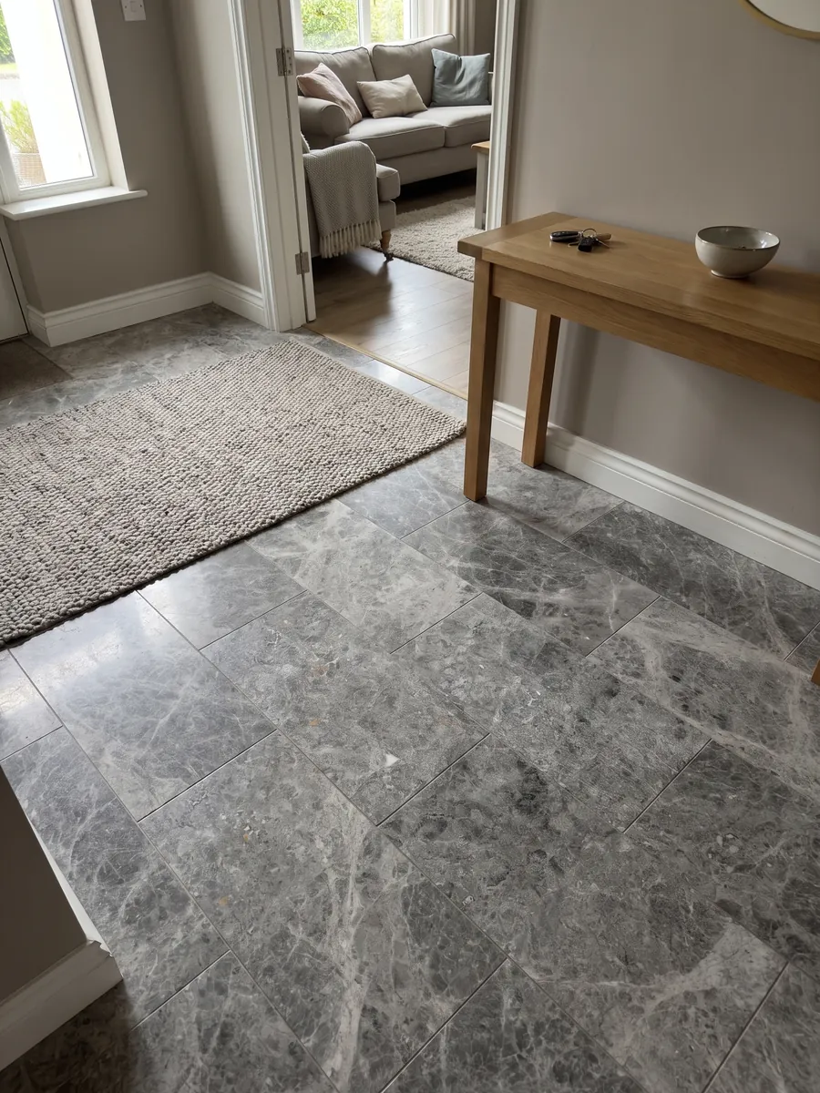 Piso de recibidor en placas grandes de mármol gris Tundra con luz natural: gris medio con nubes más oscuras y salpicado fino de puntos claros