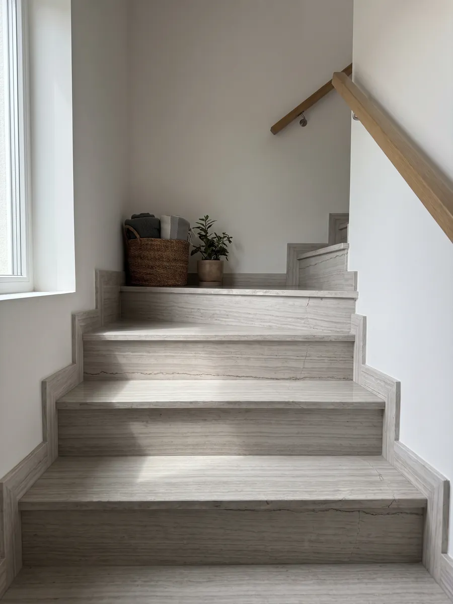Escalera interior con peldaños de mármol gris White Wood con pasamanos: gris claro con líneas horizontales finas que imitan la fibra de la madera