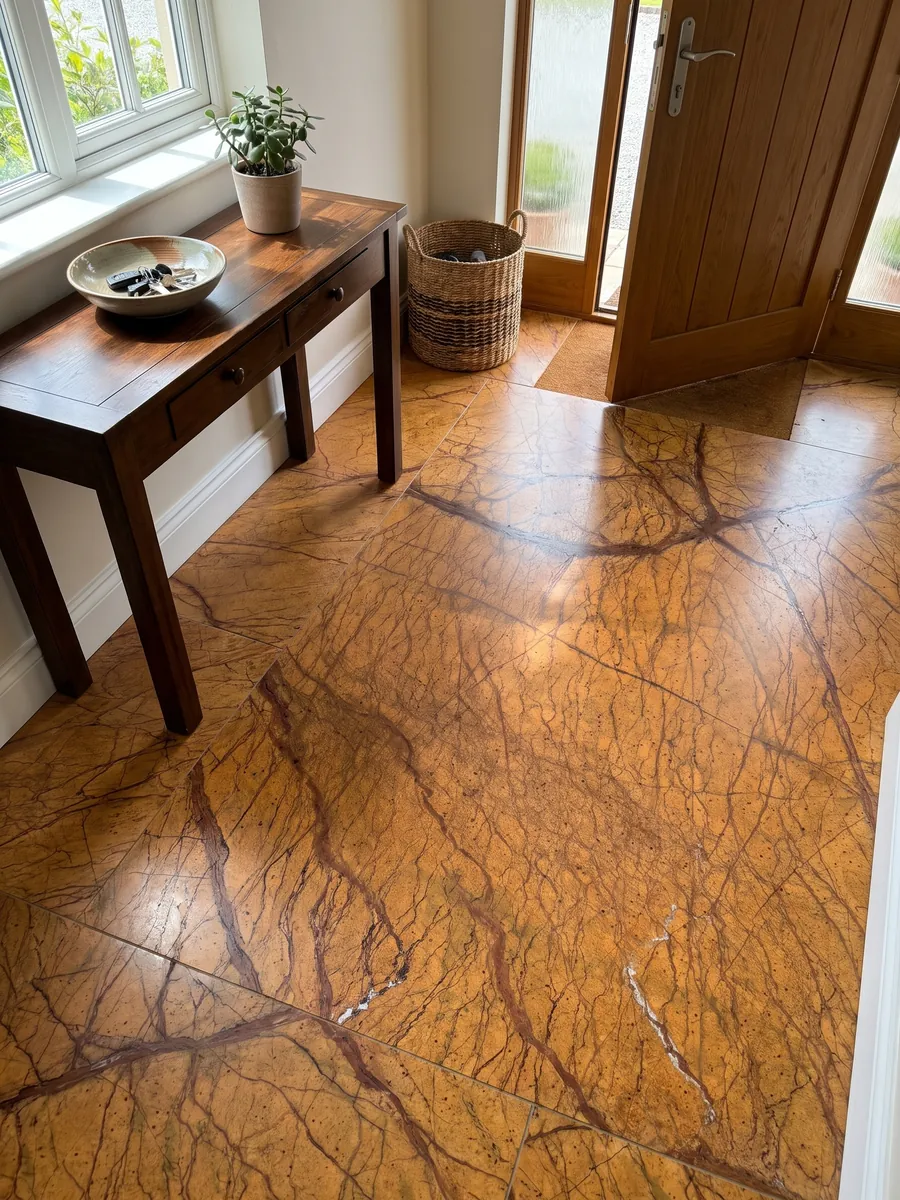 Piso de recibidor en placas grandes de mármol naranja Picasso Gold con luz natural: naranja ocre intenso con una red de vetas marrón rojizo ramificadas