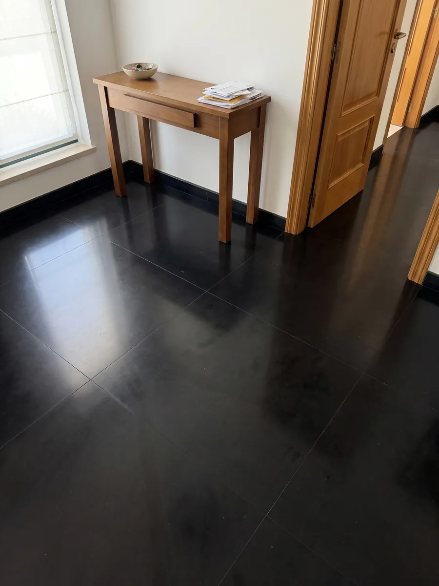 Piso de recibidor en placas grandes de Mármol Negro Belgio con luz natural: negro completamente liso y homogéneo, sin vetas ni manchas