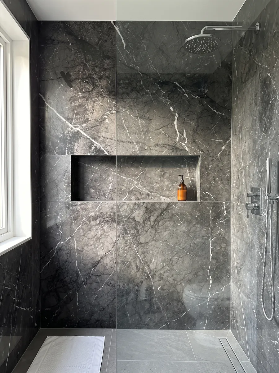 Ducha revestida con placas enteras de mármol negro Grigio Carnico con nicho empotrado: negro grisáceo con vetas blancas finas y nítidas que se ramifican