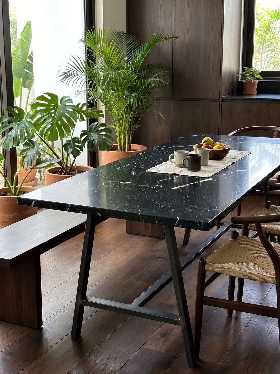 Mesa de comedor con cubierta de mármol negro Nero Marquina sobre base de acero: negro profundo con pocas vetas blancas finas y rectas