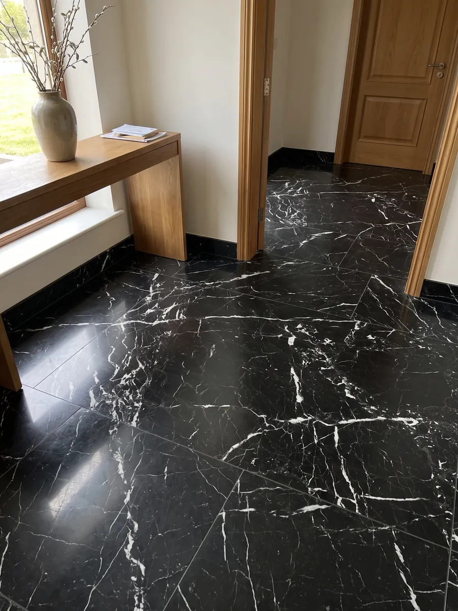 Piso de recibidor en placas grandes de mármol negro Napoleon Black con luz natural: negro intenso con una red irregular de vetas blancas nítidas