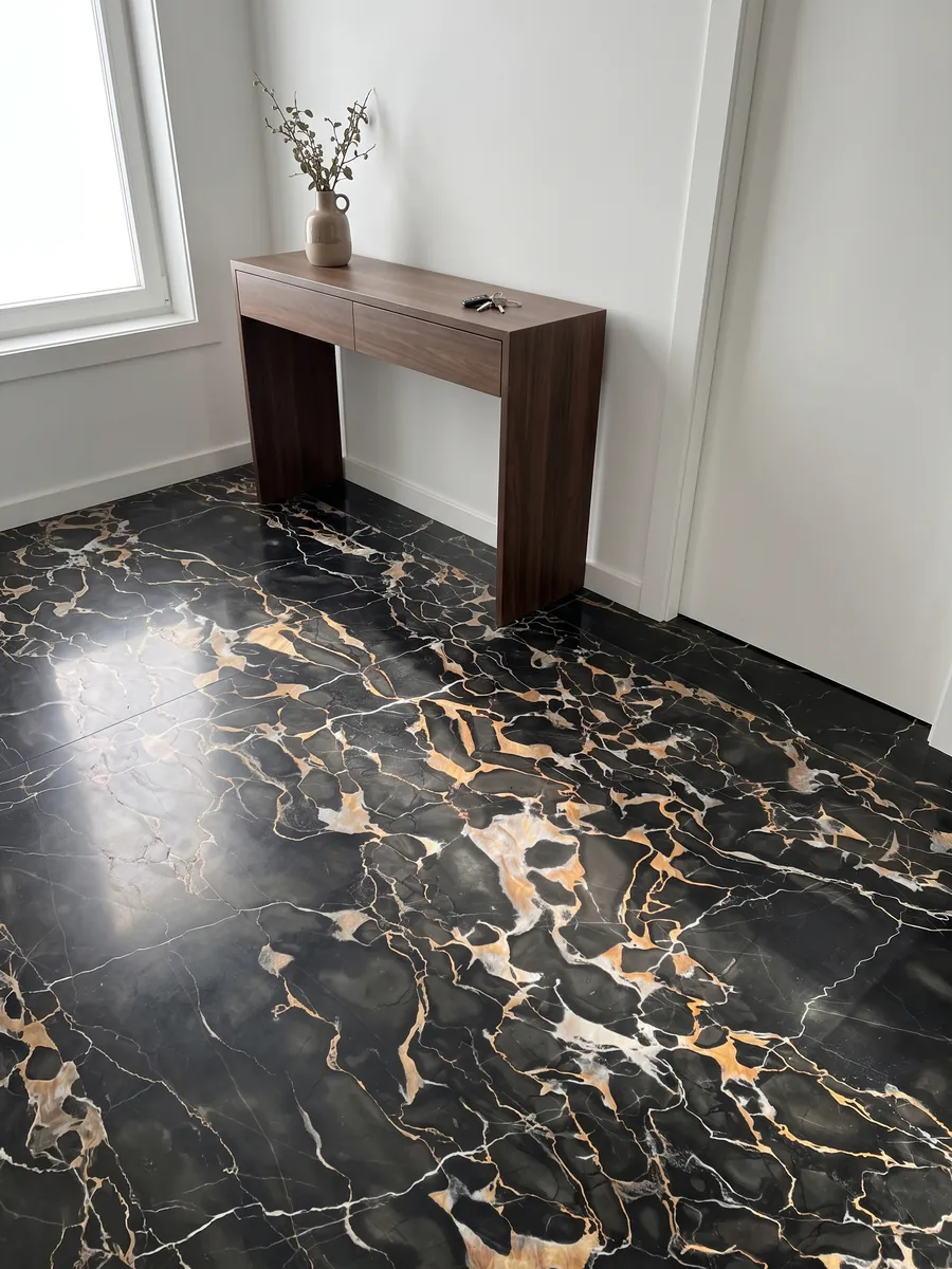 Piso de recibidor en placas grandes de mármol negro Nero Portoro con luz natural: negro con una red densa de vetas doradas y blancas