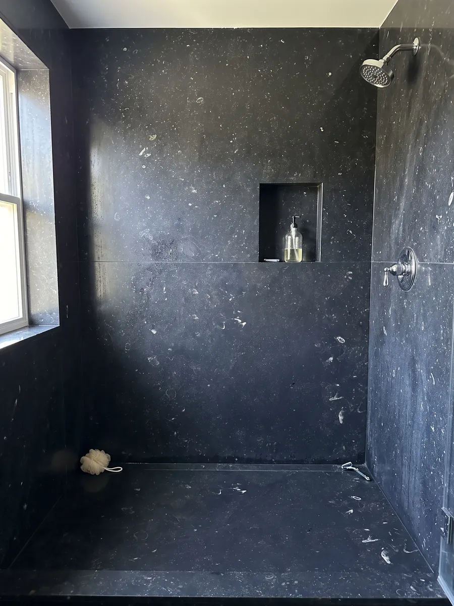Ducha revestida con placas enteras de mármol negro Pierre Bleu con nicho empotrado: negro azulado con pequeñas motas claras dispersas