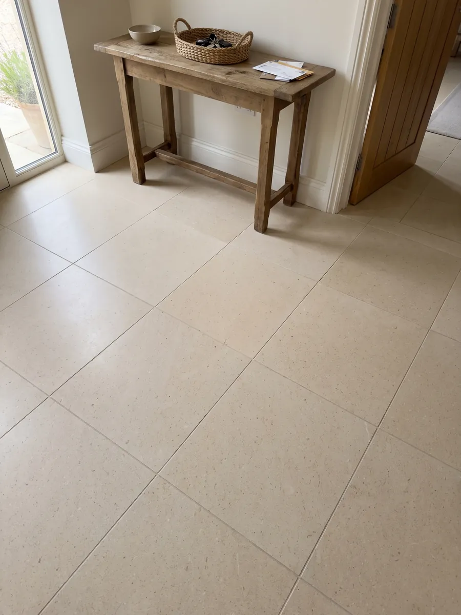 Piso de recibidor en placas grandes de Mármol New Marfil con luz natural: crema claro muy uniforme con grano fino y sin vetas